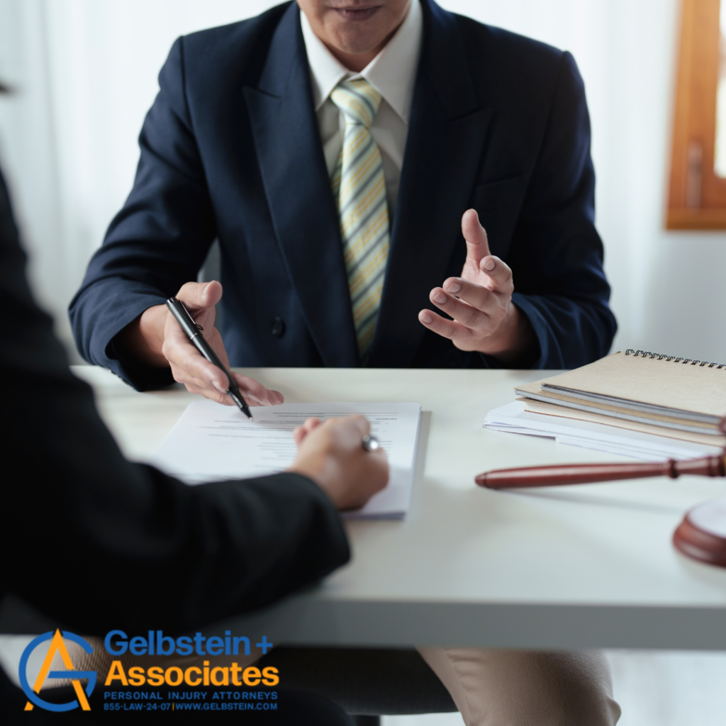 Lawyer discussing with a client who is taking notes, with paperwork and a gavel on the desk.