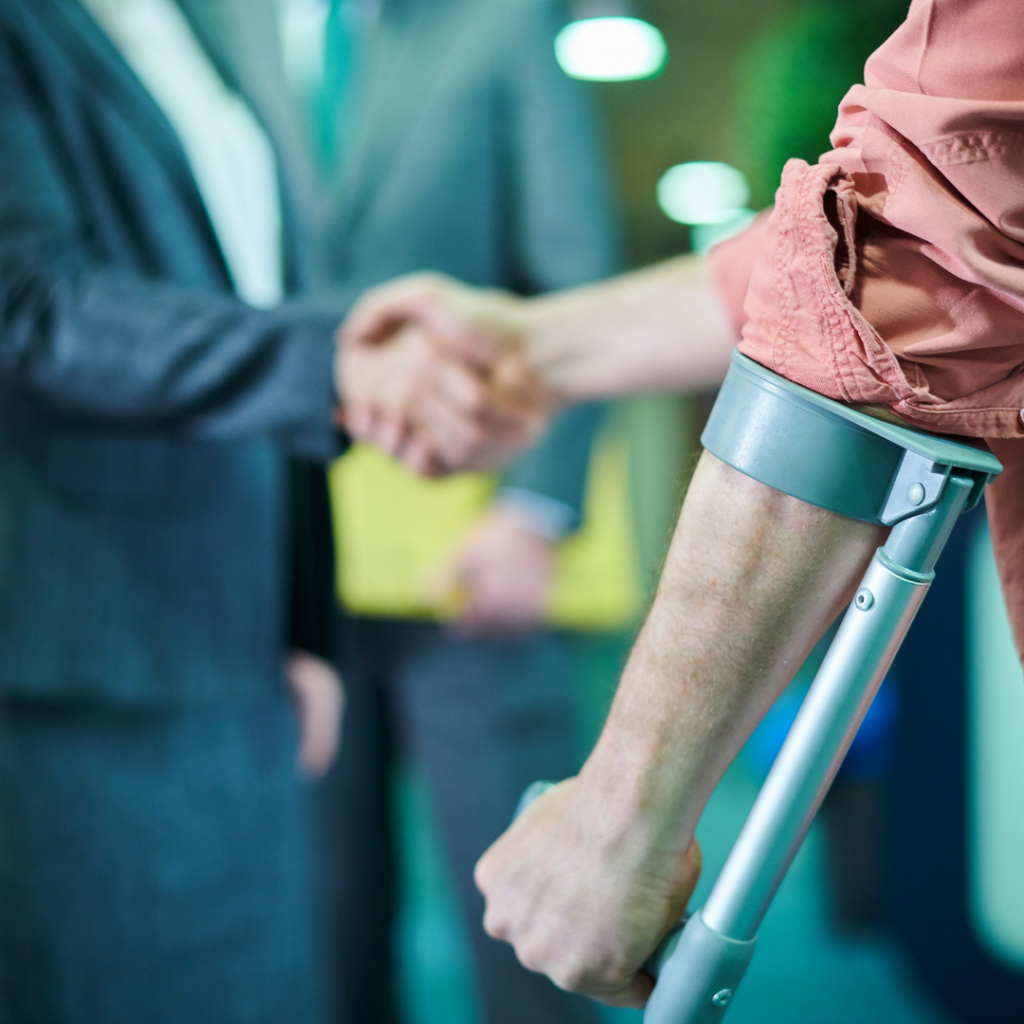 Two individuals shaking hands, one wearing a brace on his arm